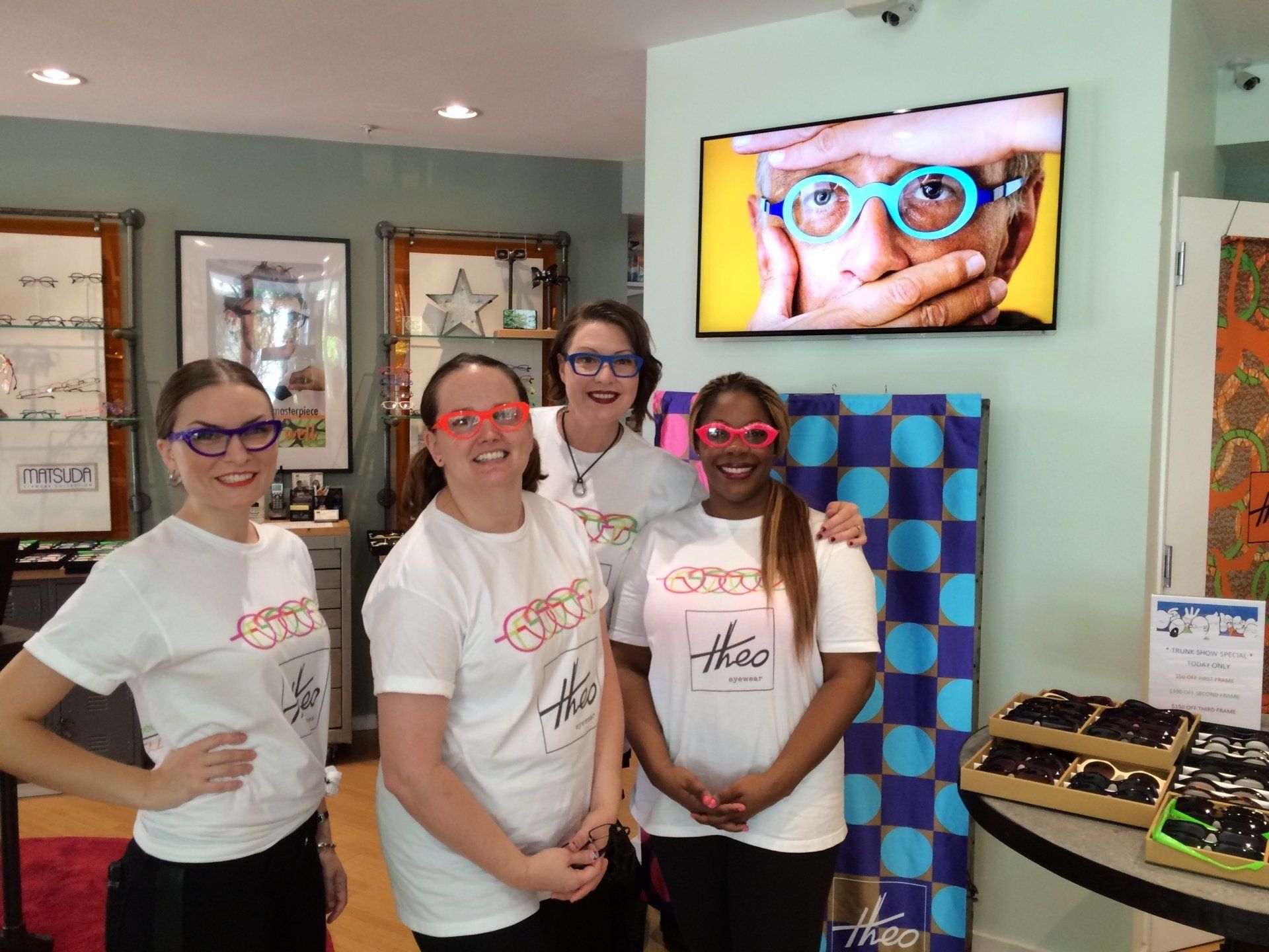 Four people wearing colorful glasses at Theo Trunk Show event at Urban Optiks
