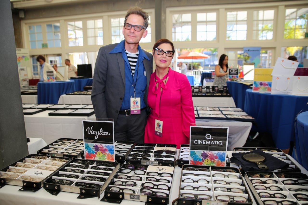 2 vendors standing behind their tabletop displays of eyewear at 2018 Raise Your Glasses