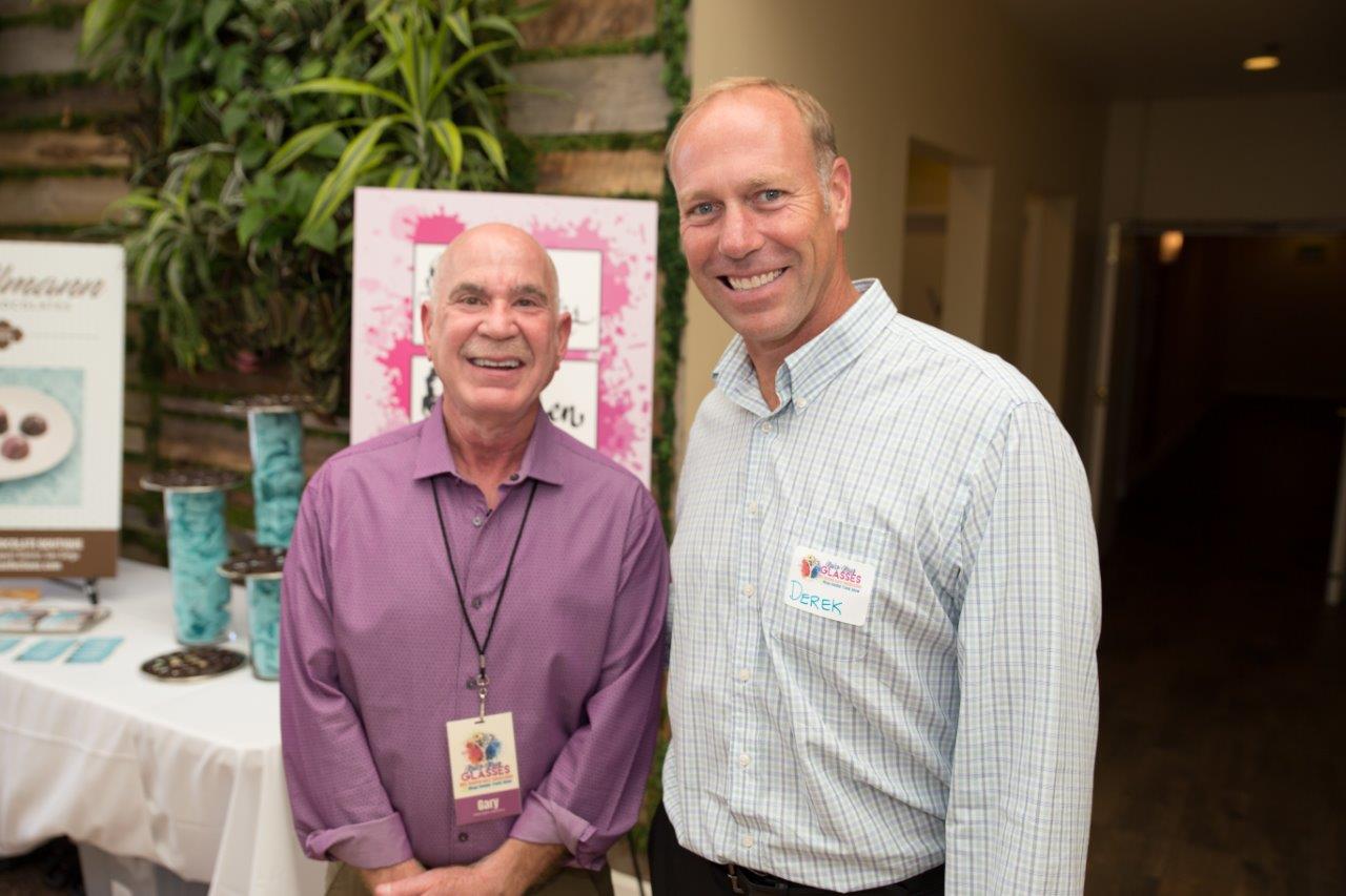 Dr Klein and guest standing inside at Raise Your Glasses 2018 Event