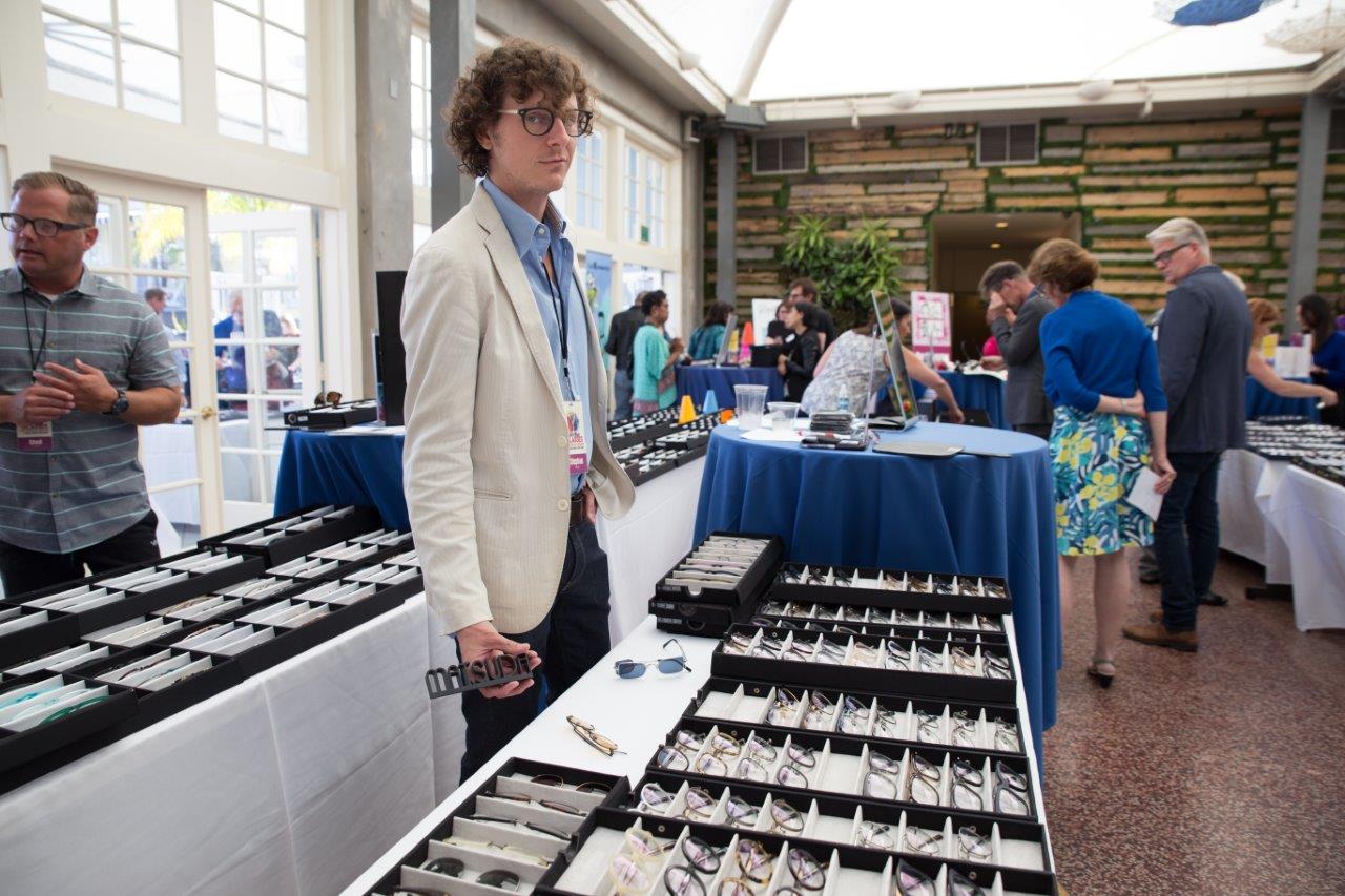 Vendor standing behind his tabletop display at Raise Your Glasses 2018 Event