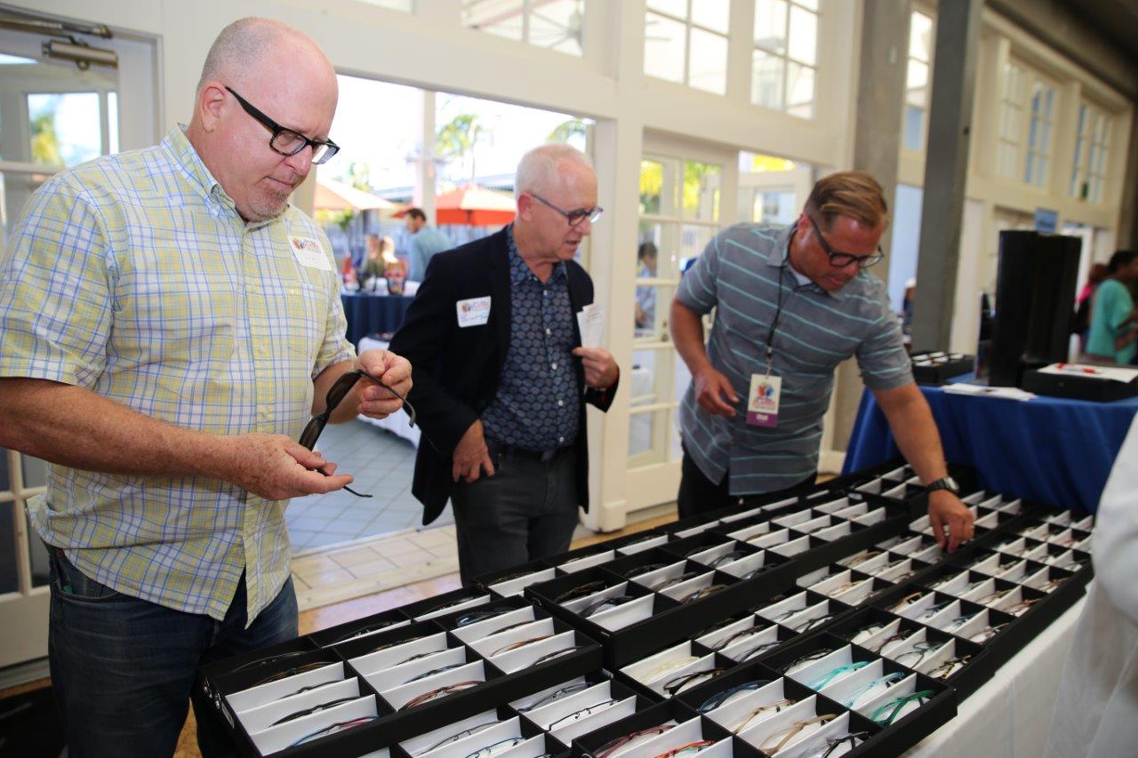 Shoppers looking at frame selections in display boxes during Raise Your Glasses 2018 Event