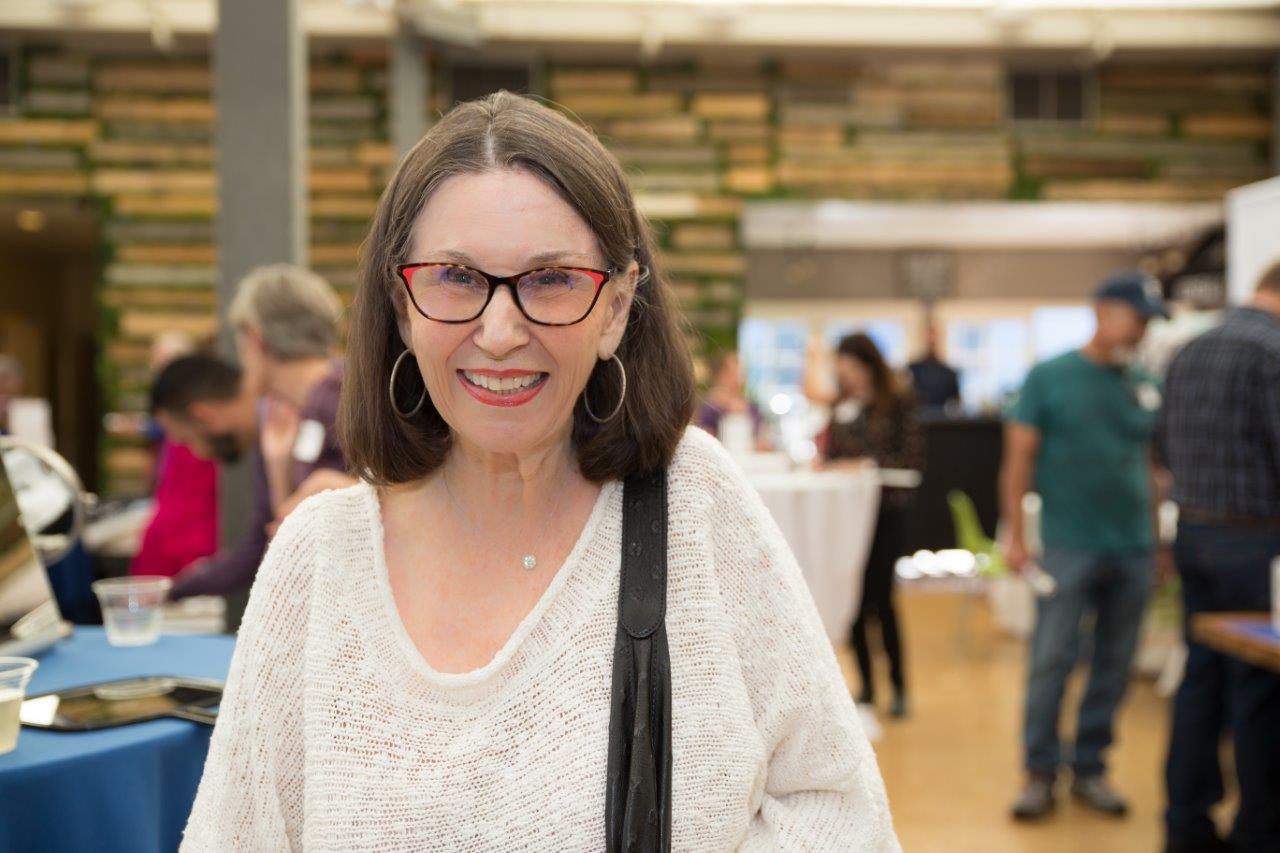 Woman wearing glasses standing indoors during Raise Your Glasses 2018 Event