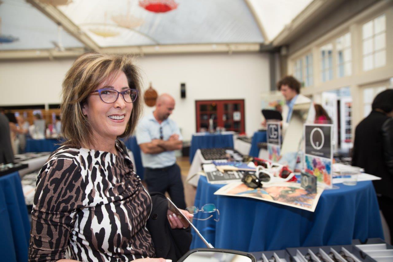 Person wearing glasses and smiling at Raise Your Glasses 2018 Event
