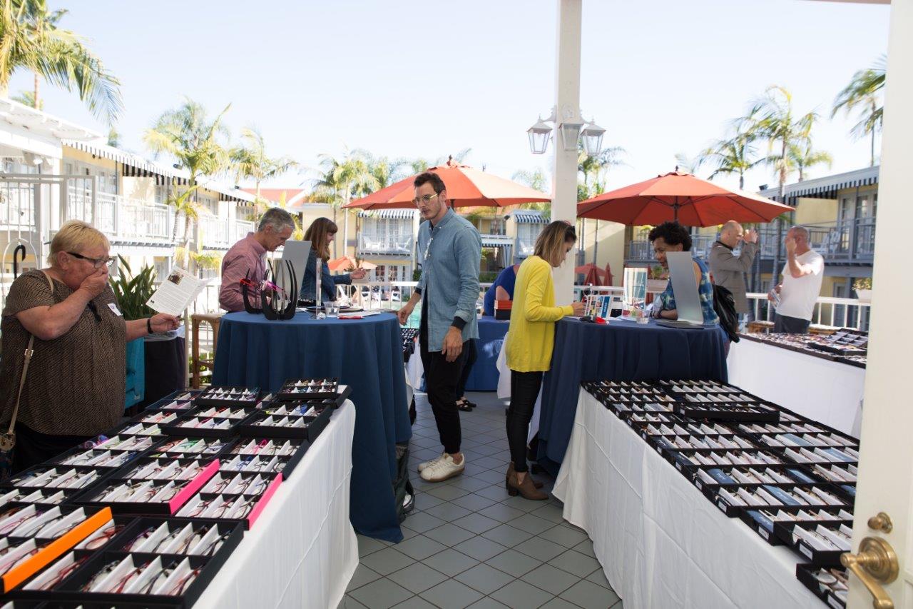 Shoppers looking at many tabletop frameline displays at Raise Your Glasses 2018 Event