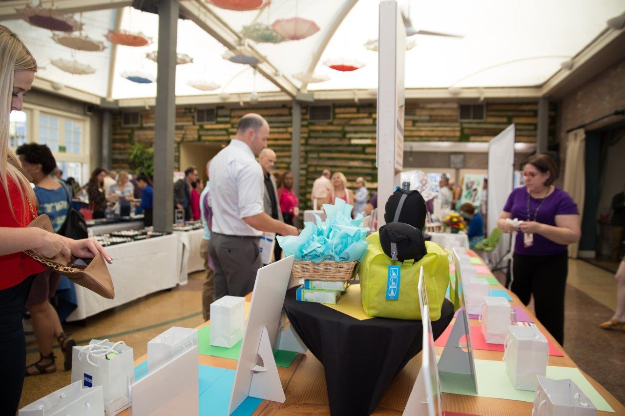 Person looking at gift bags for drawings at Raise Your Glasses 2018 Event