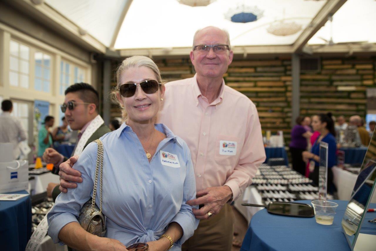 Woman in sunglasses and man in eyeglasses smiling at Raise Your Glasses 2018 Event