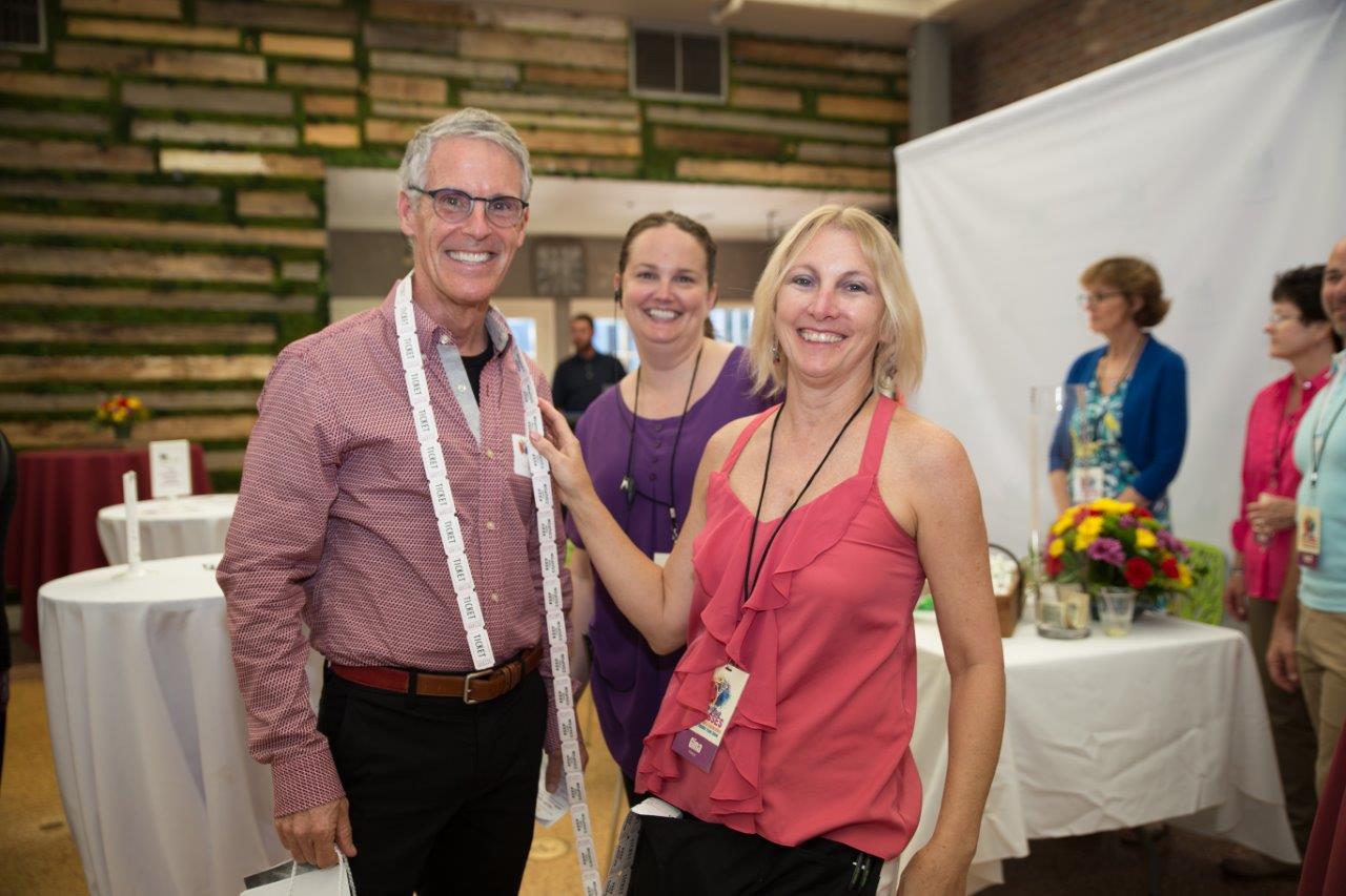 3 people posing with drawing tickets at Raise Your Glasses 2018 Event