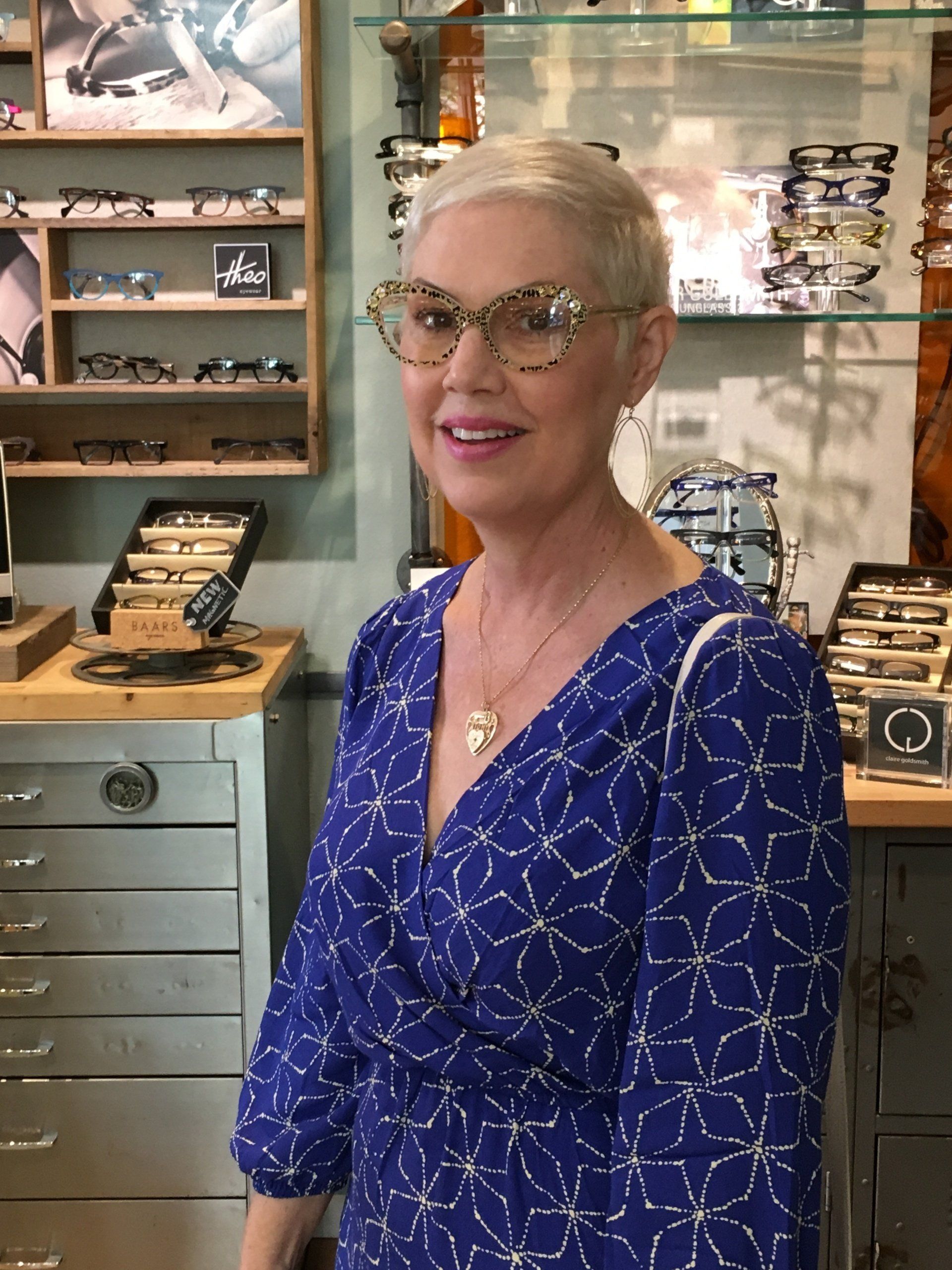Person in blue dress trying on frames at 2017 Francis Klein Trunk Show