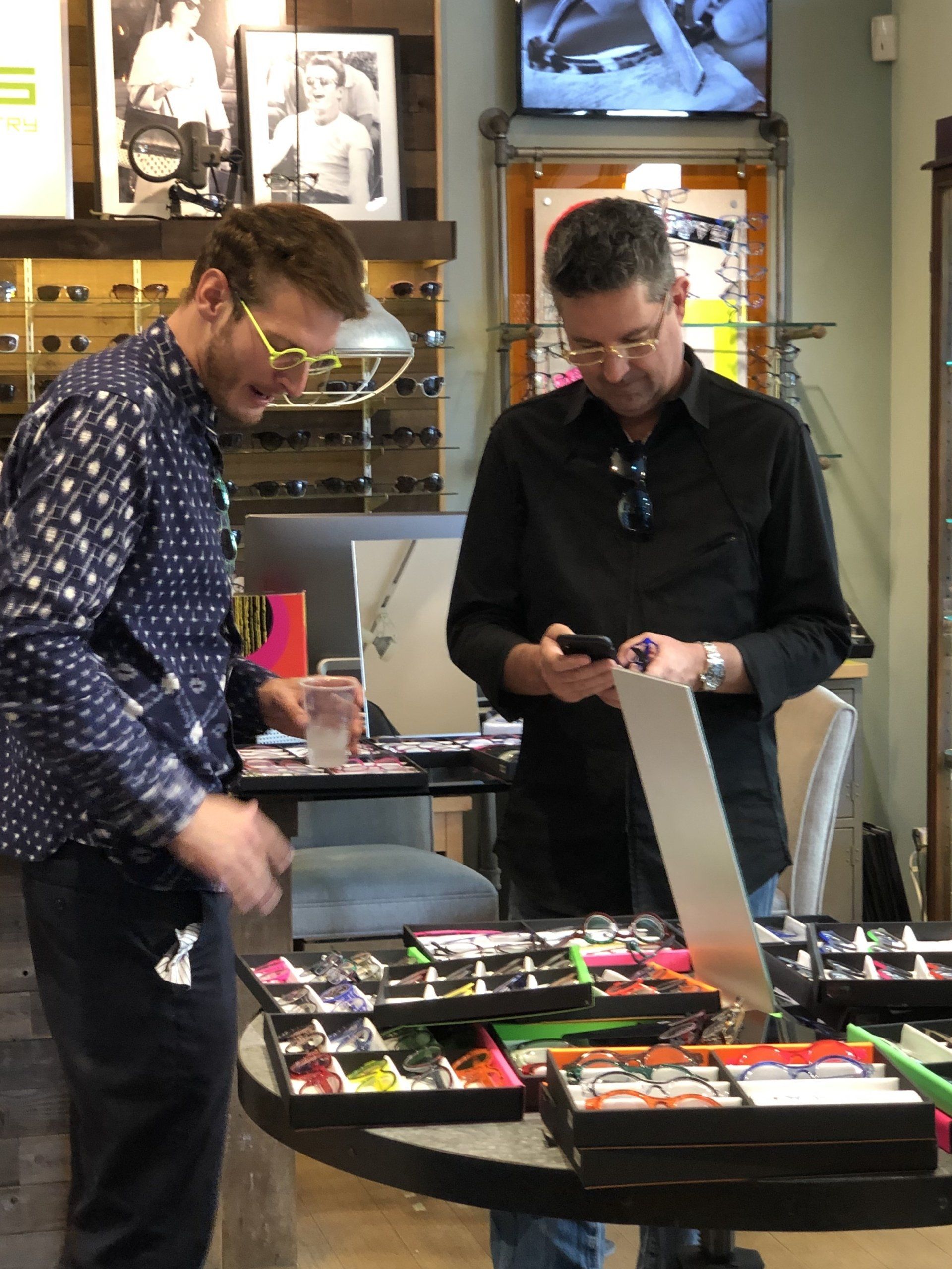 Two people standing near table at Theo Trunk Show Event