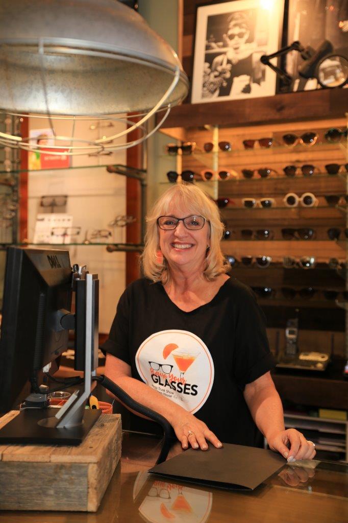 Person in event t-shirt standing inside Urban Optiks Optometry at Raise Your Glasses 2017 Event