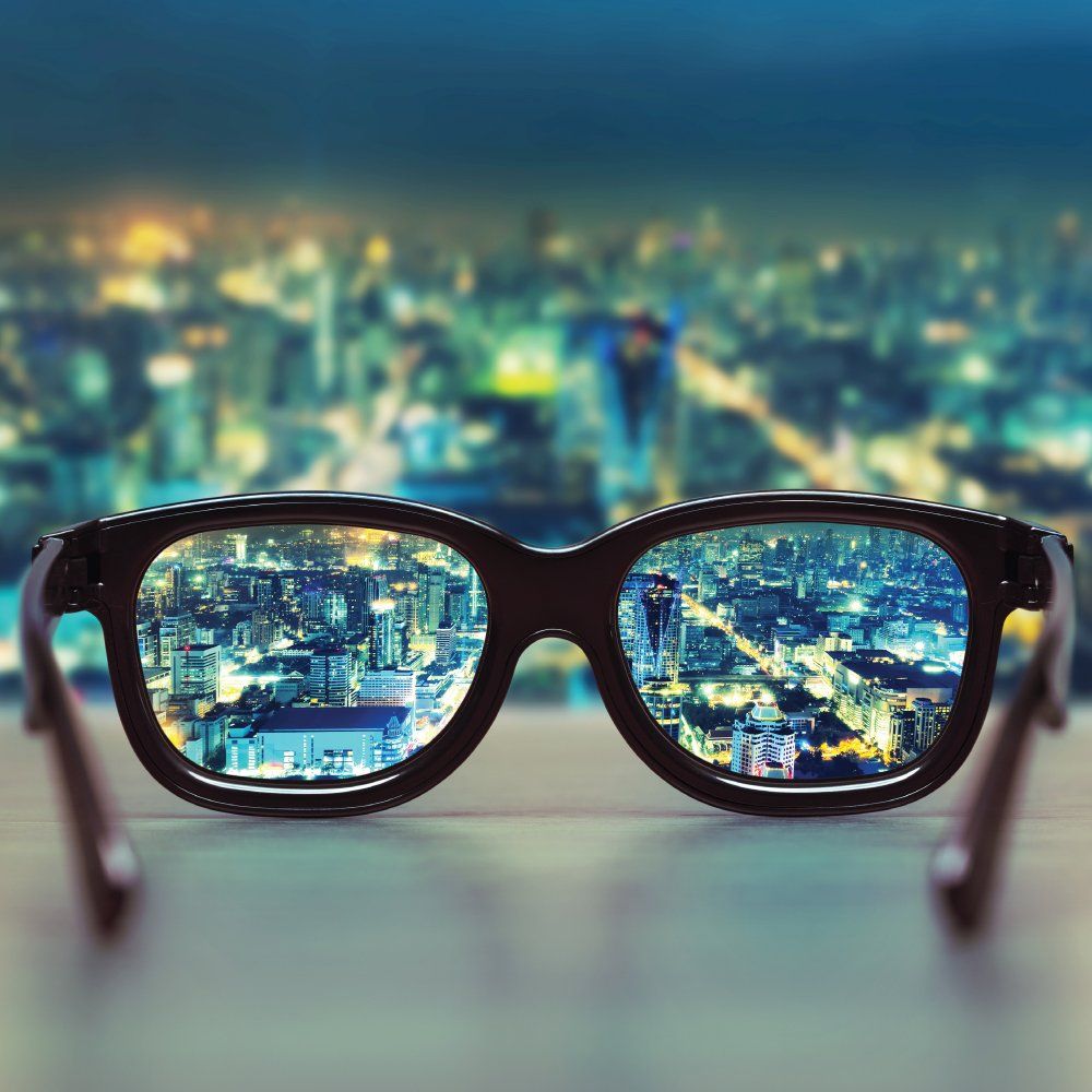 Blurred view of city and close-up of clear image through glasses