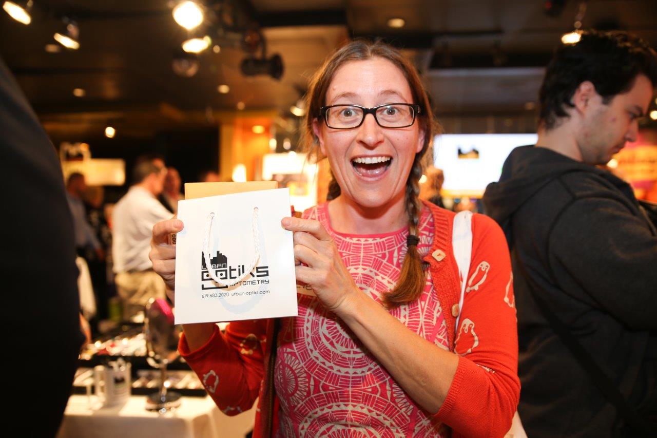 Woman holding brochure at Raise Your Glasses event