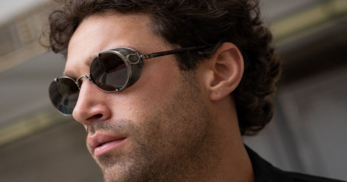 A close up of a man wearing a biar of bronze colored matsuda sunglasses