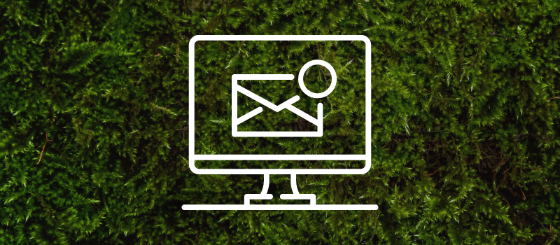 A line drawing of a computer screen with an envelope on it on a green moss background