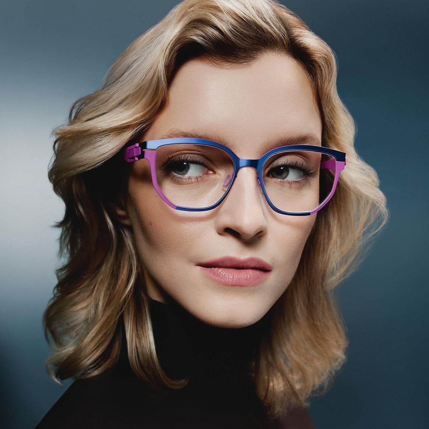 A woman wearing a pair of blue and pink glasses