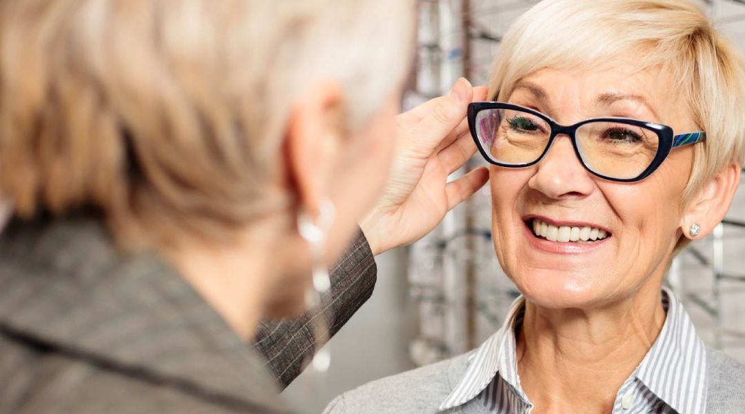 An optician adjusting a pair of glasses on a womans face