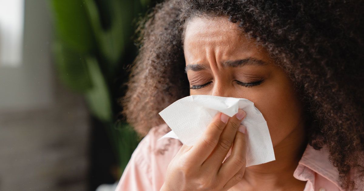 A woman is blowing her nose into a napkin.