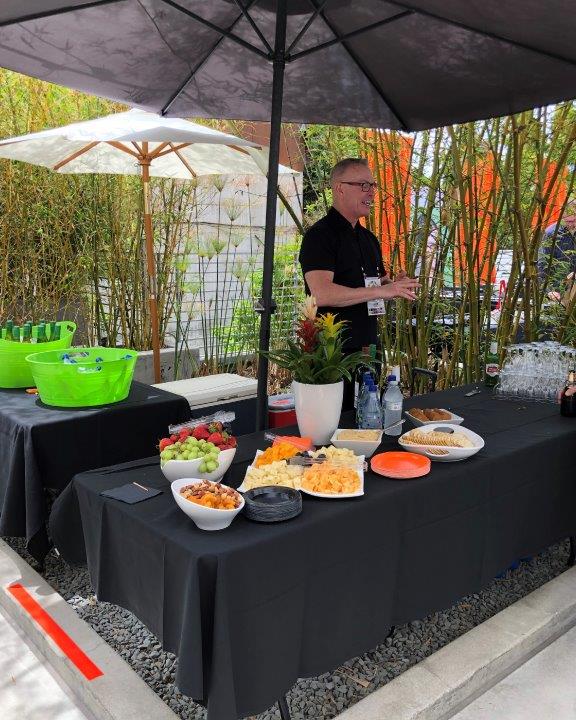 Server standing behind food table at Raise Your Glasses 2019 Event