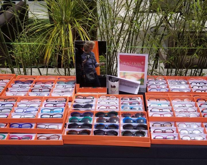 Many colorful eyeglass and sunglass frames in orange display boxes at 2019 Raise Your Glasses Event