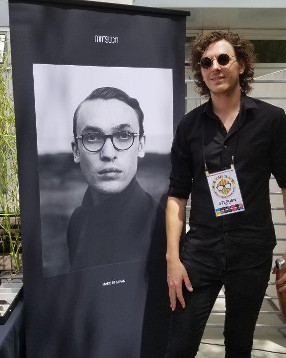 Vendor posing in front of large Matsuda banner at  2019 Raise Your Glasses Event