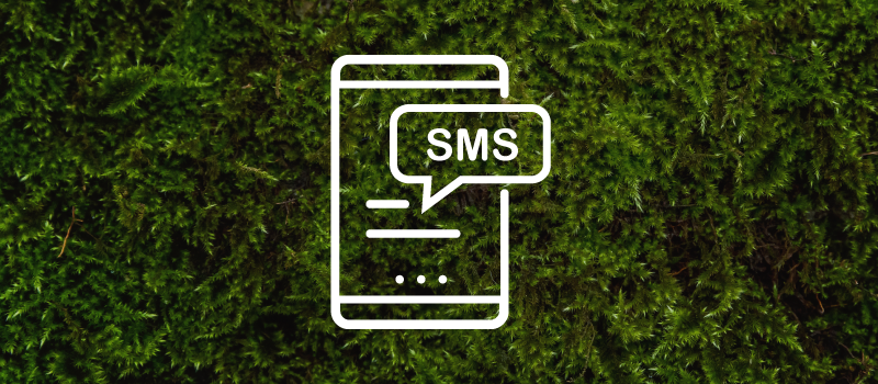 A line drawing of a mobile phone with an sms bubble on a green moss background.
