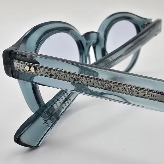 Close up detail of a translucent teal frame with ornate metal details