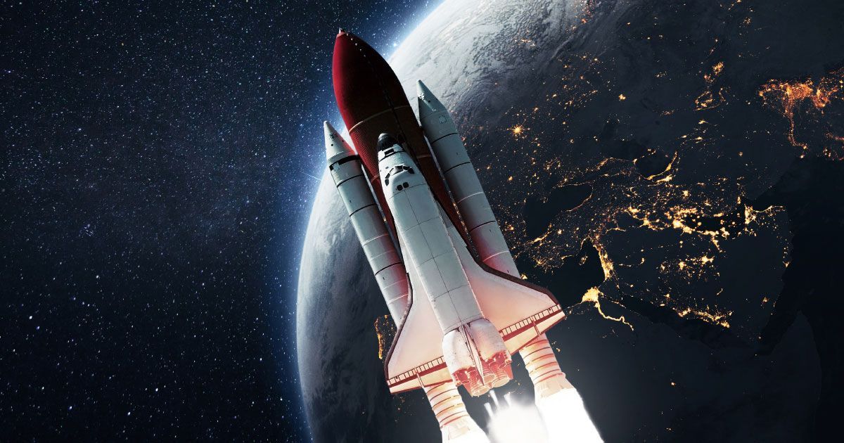 A space shuttle is flying over the earth in space.