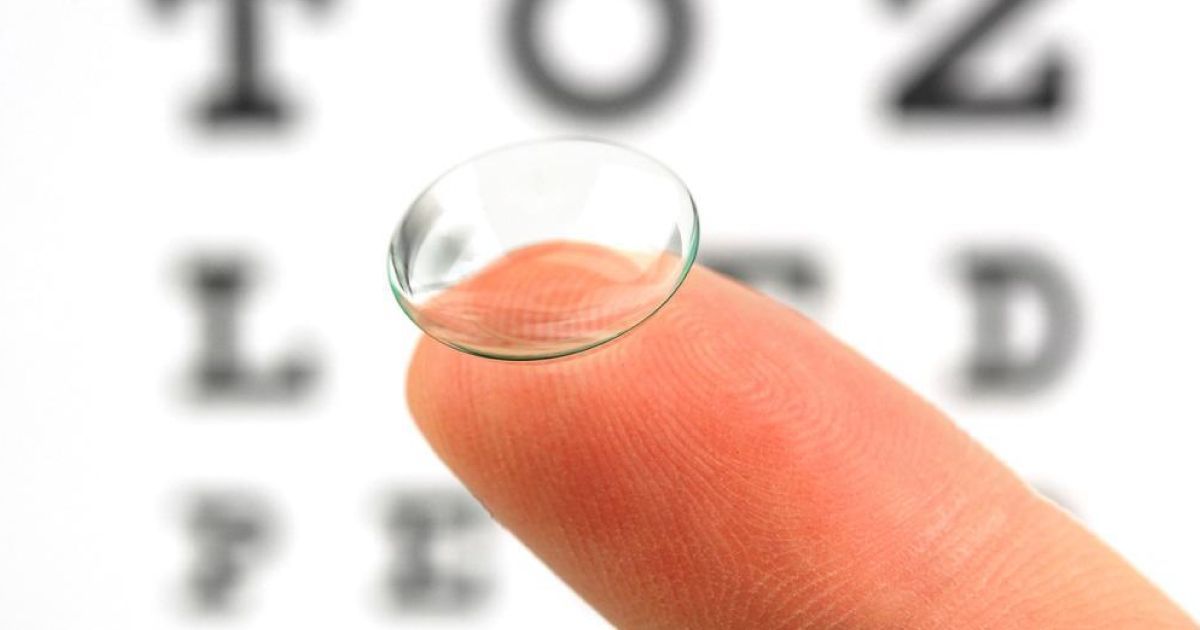 A close up of a person 's finger with a contact lens on it.