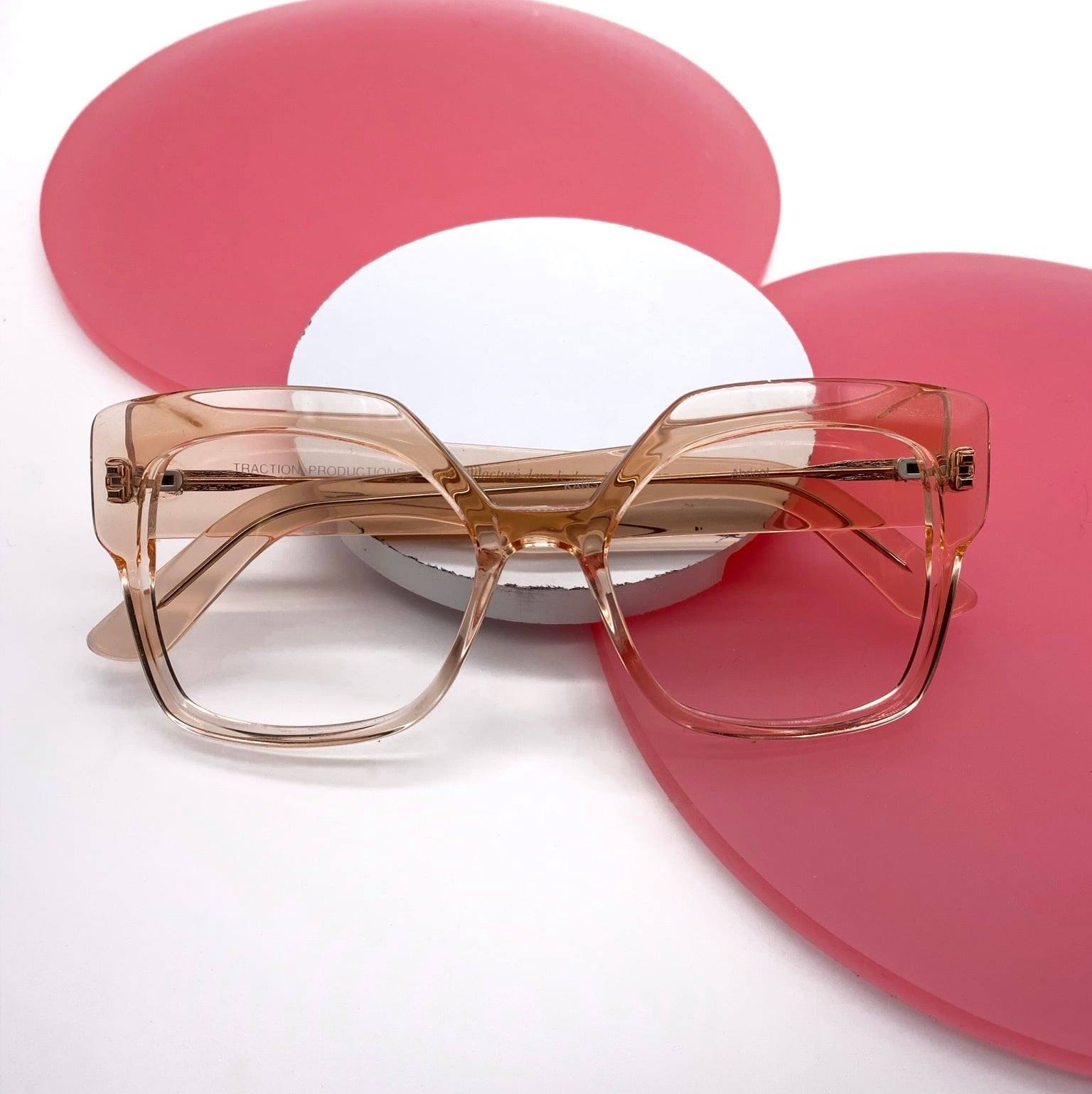 Translucent Traction Productions eyeglass frame on pink and white background