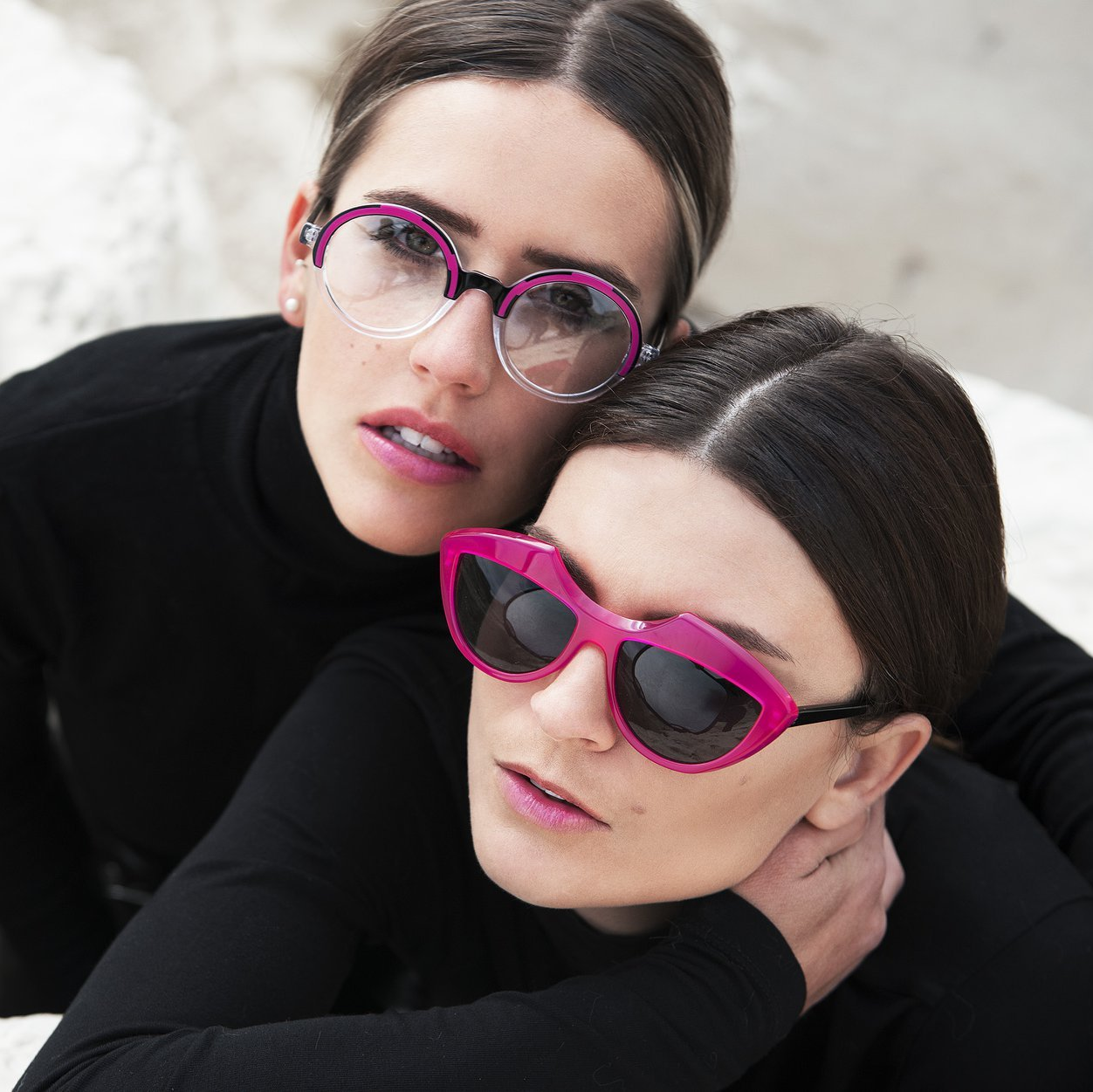 Two women wearing colorful Traction Productions eyeglass frames