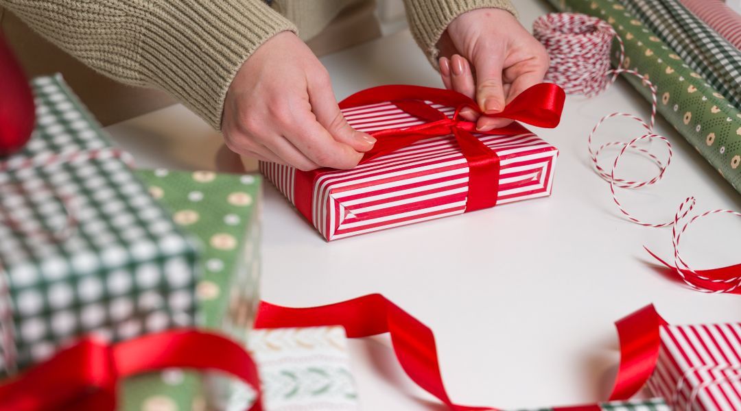 Unrecognizable female wrapping christmas gifts on the table