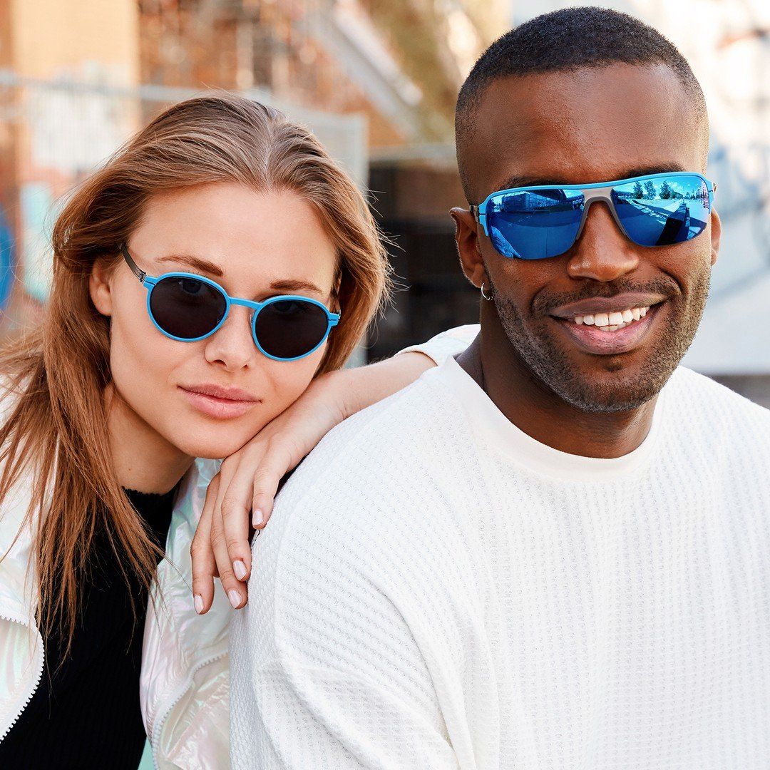 Woman and man wearing blue ic! berlin sunglasses in blue with mirror tint