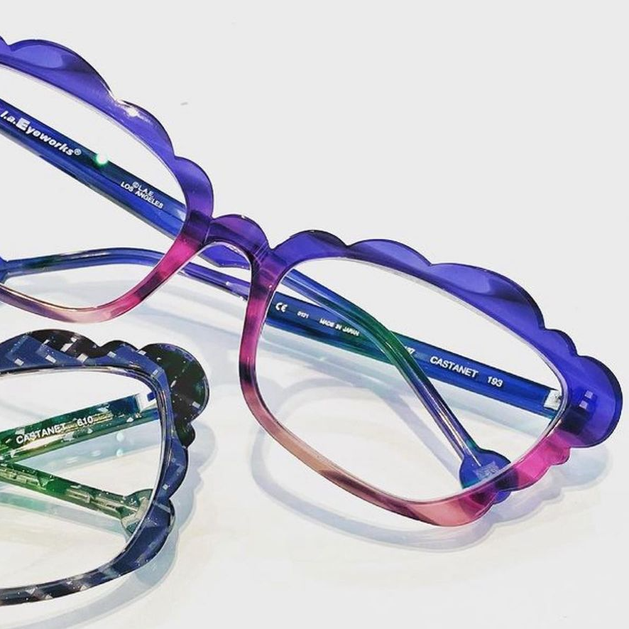 Two  la Eyeworks frames with scalloped  edges in pink, purple, and greens