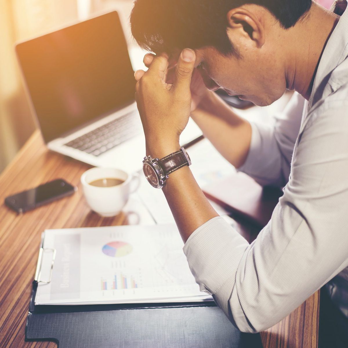 A man sitting at a desk with his head in his hands