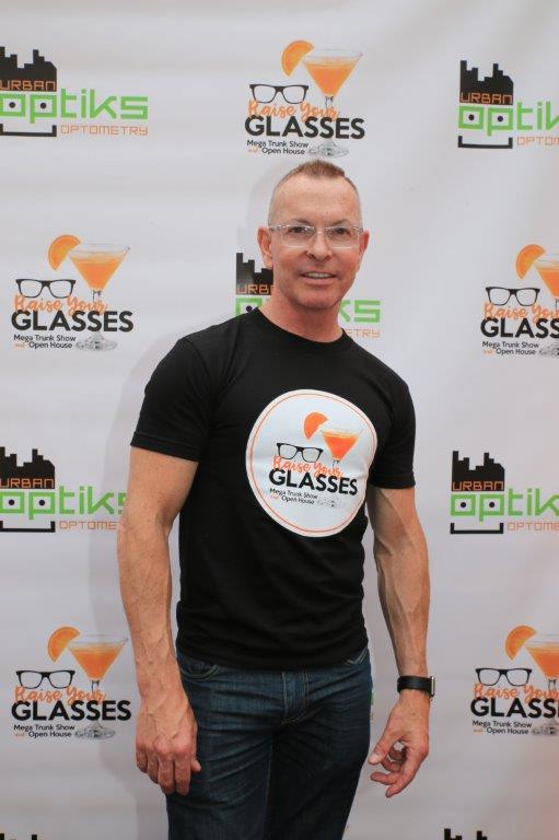 Person posing in front of banner at Raise Your Glasses 2017 Event