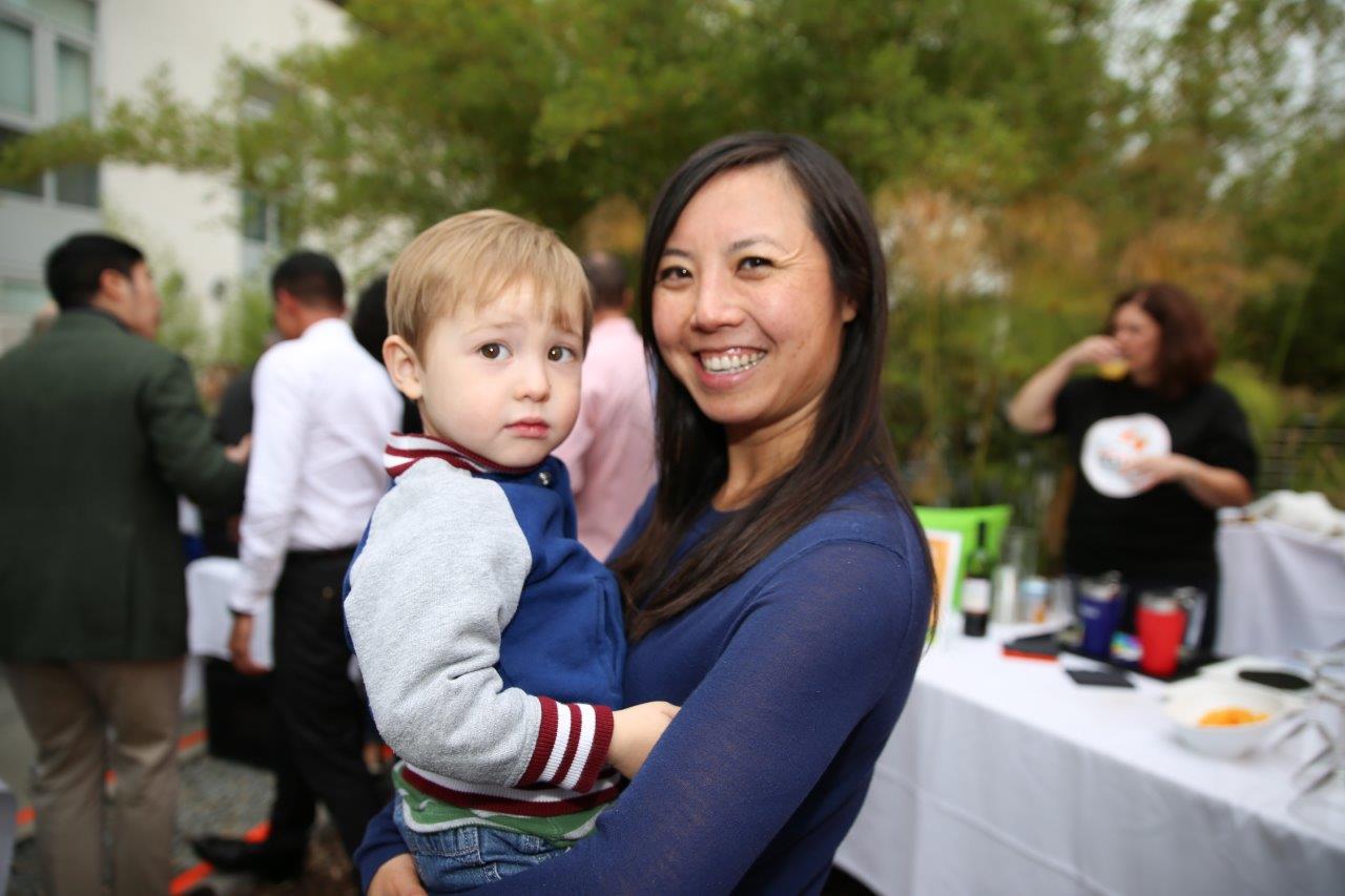 Woman holding small child at Raise Your Glasses 2017