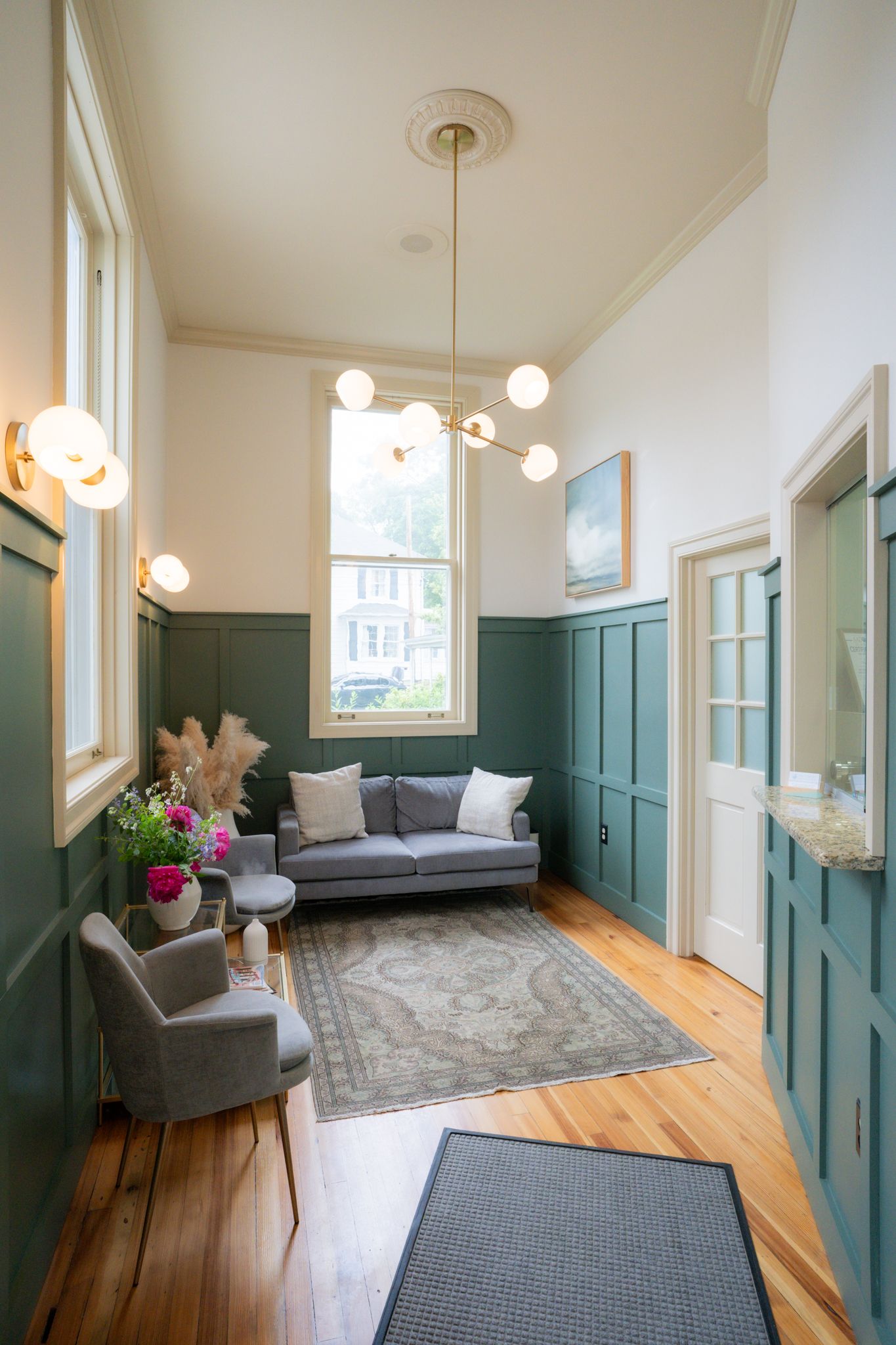 A living room with a couch , chairs , and a rug.