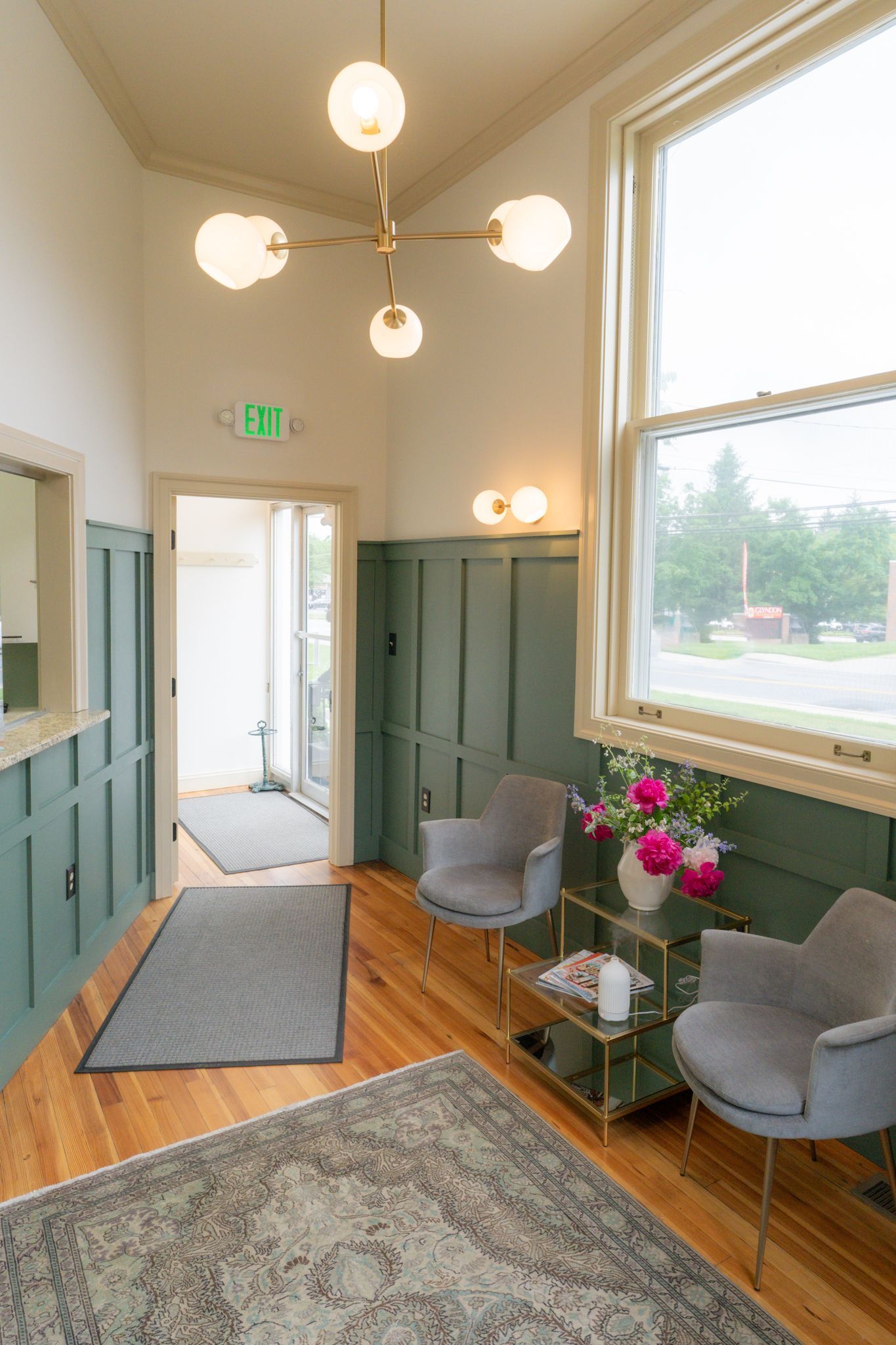 A waiting room with two chairs and a vase of flowers.