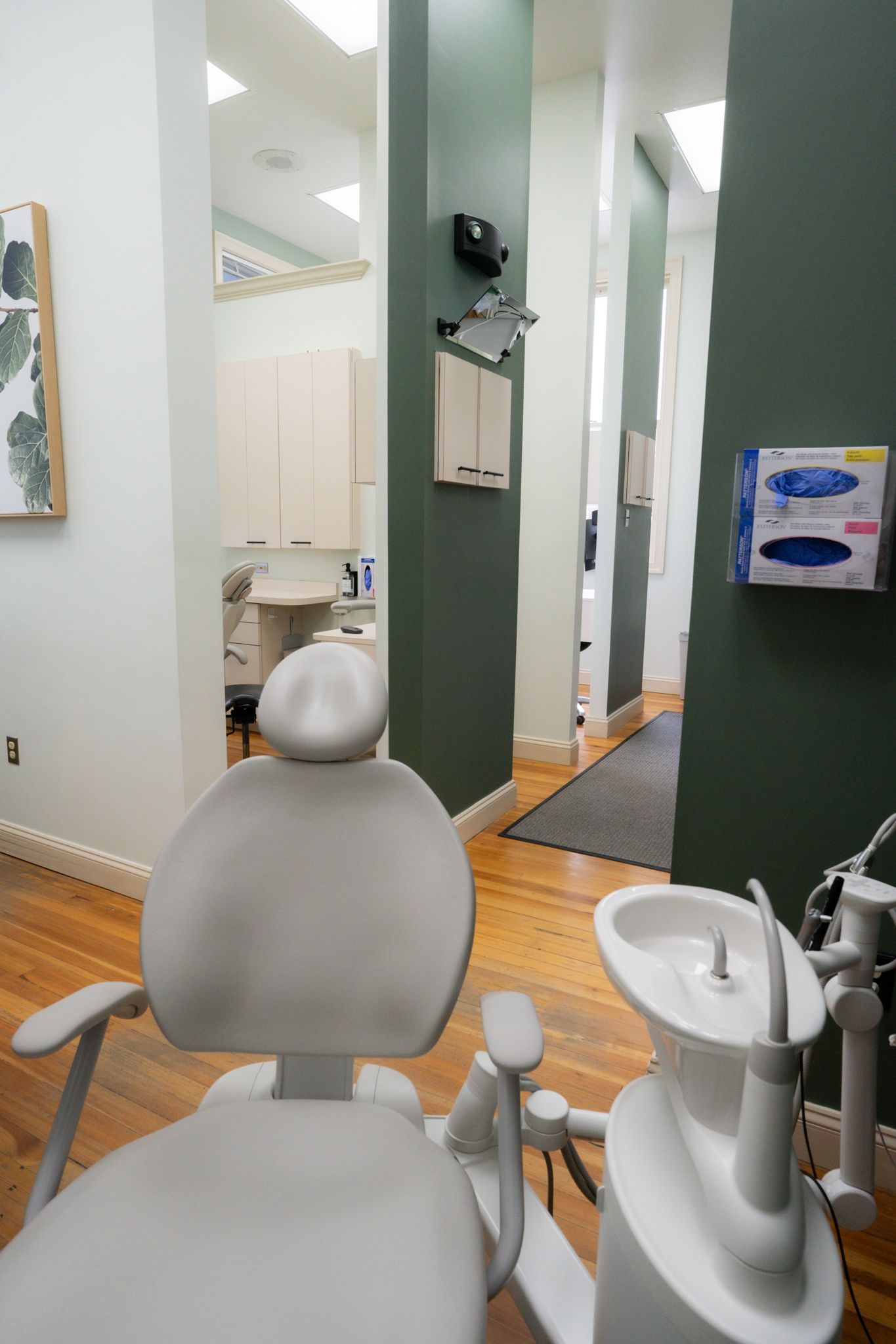A dental office with a dental chair and a sink.