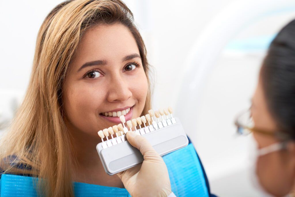 A woman is getting her teeth whitened by a dentist.