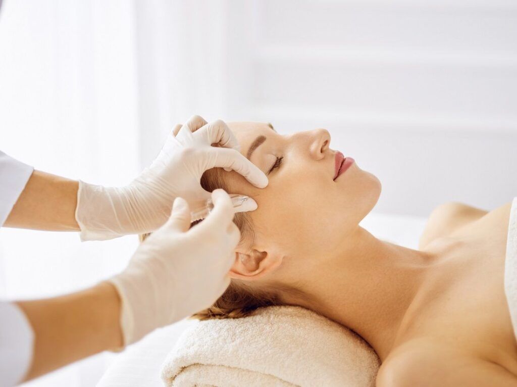 A woman is getting a facial treatment at a spa.