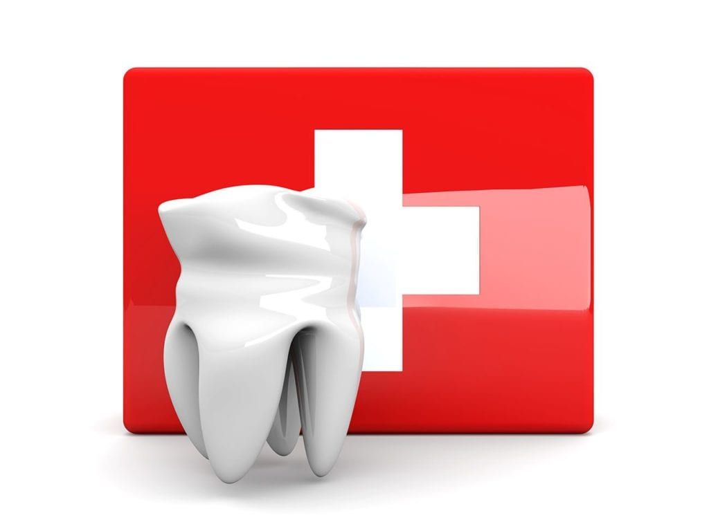 A tooth is sitting in front of a swiss flag
