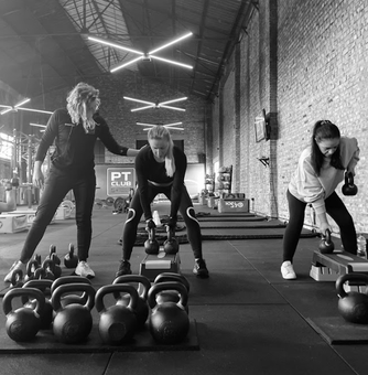trainer geeft tips tijdens de krachttraining. Persoonlijke fitness begeleiding voor vrouwen.