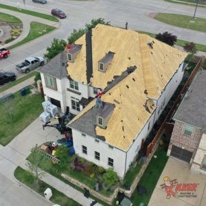 An aerial view of a house with a roof that is being repaired