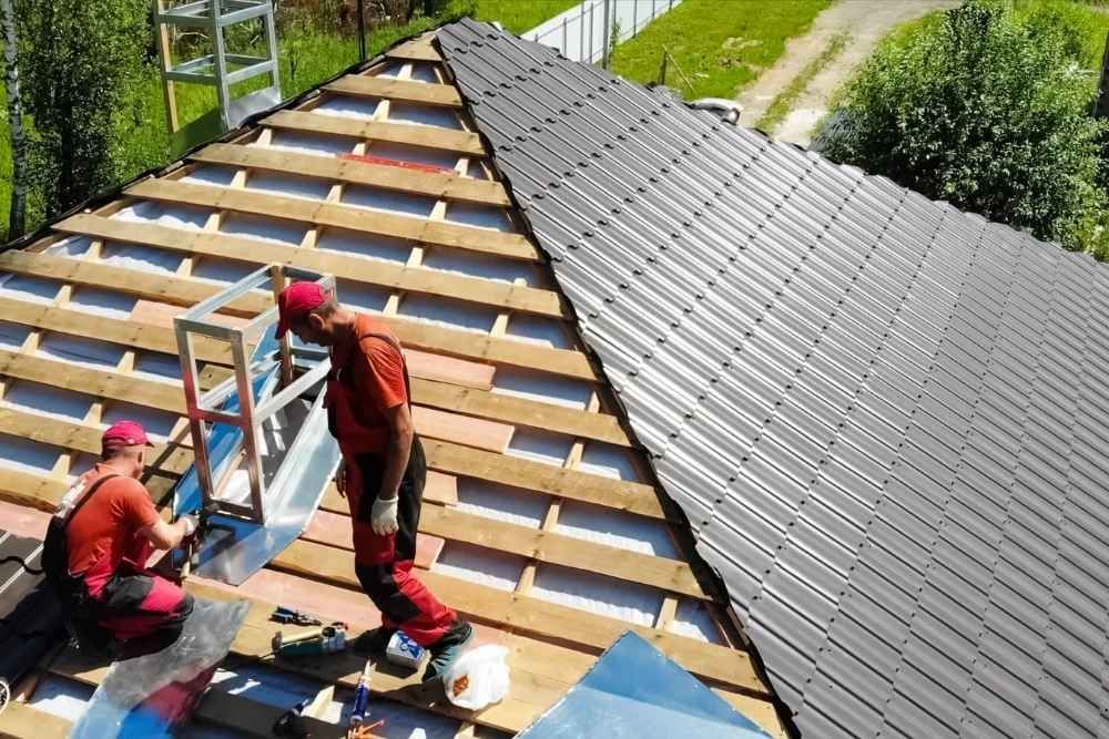 Two men are working on the roof of a house.