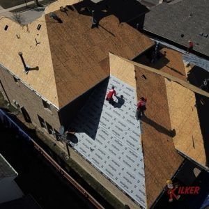 An aerial view of a roof being installed on a house