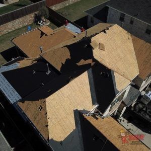 An aerial view of a roof being installed on a house.