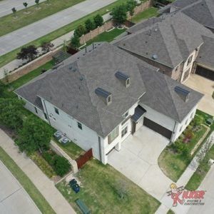 An aerial view of a house with a gray roof