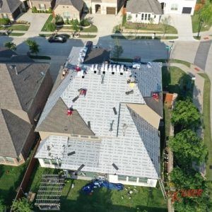 An aerial view of a house with a new roof being installed.