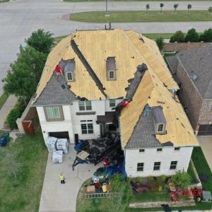 An aerial view of a house with a roof that is being repaired.